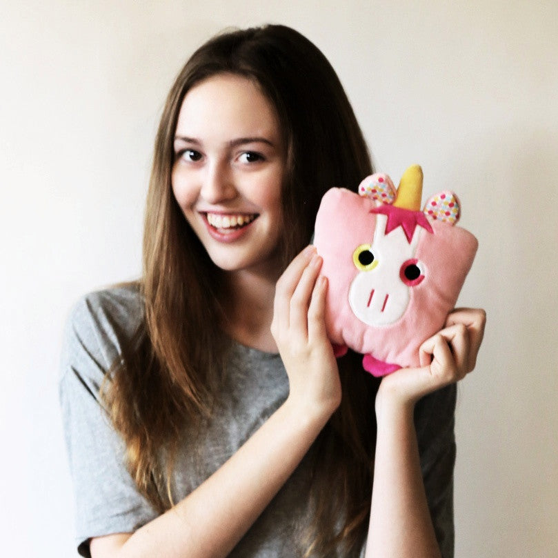 Plush toy unicorn stuffed animal with a useful back pocket, designed by young entrepreneurs